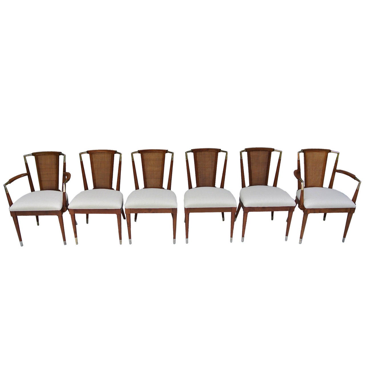 Six cane and brass dining chairs Bert England Forward Trend line for Johnson Furniture Company in the 1950s. 
The six cherrywood caned back dining chairs with brass sabots and brass crest rail and armrest details.
All of the metal pieces are brass