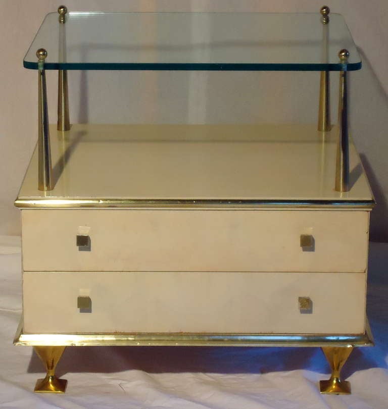 Sophisticated brass glass and translucent Ivory lacquer over strongly grained walnut give this nightstand/ end table visual interest. Designed by Renzo Rutili, the head of design at Johnson Furniture for 30+ years. 
The case rests on gold toned