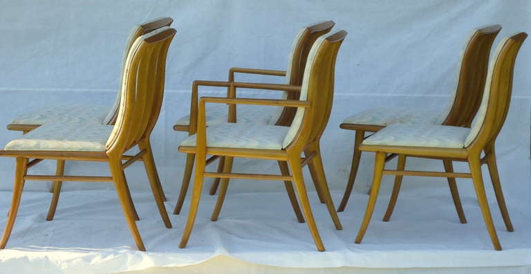 Suite of six saber leg T.H. Robsjohn- Gibbings dining chairs (2 armchairs, 4 side chairs. Manufactured by Widdicomb in 1953. These are Model No. 4204's and are in Sherry which give the walnut frames a sandalwood color. 
The set retains its original