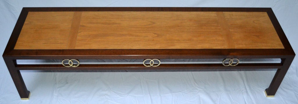 A walnut cocktail table designed for Baker in the 1950s by Michael Taylor for the Far East collection. 
A segmented palomino-colored  stained top is placed on a framework of dark stained walnut. 
The side rails have eight pairs of polished brass