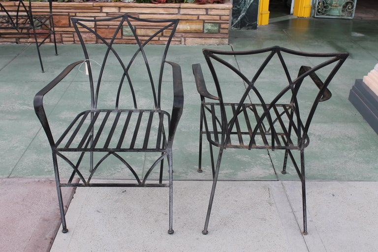 Pair of Hollywood regency wrought iron patio chairs.  Gothic in appearance and In the manner of Salterini
