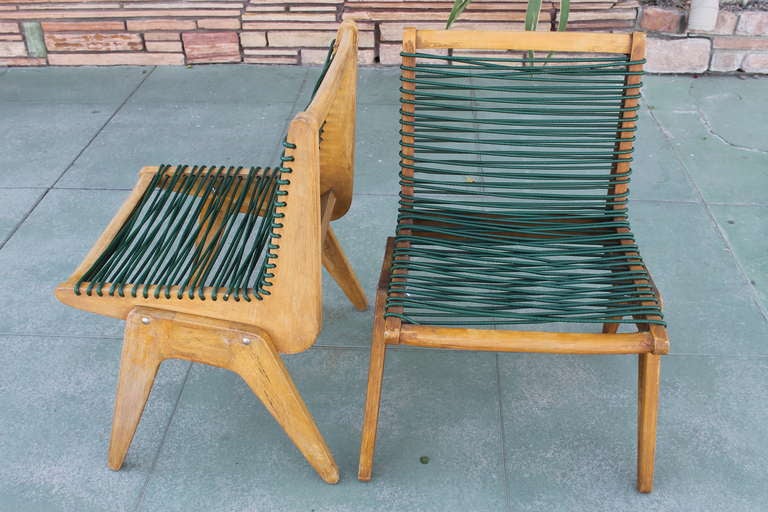 Pair of wooden rope chairs in the manner of Klaus Grabe.   Hardwood chairs with original natural blonde finish and original green plastic covered rope. Legs are attached with wing-nut and bolt construction. These measure 31” high at the back, 21”
