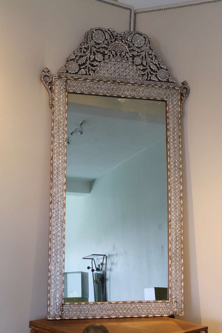Large Moroccan bone and mother of pearl inlay mirror. Massive solid ebony frame is heavily encrusted with mother of pearl and silver inlay. Borders are raised inlaid stripes of bone and ebony. There are some very minor losses and cracking