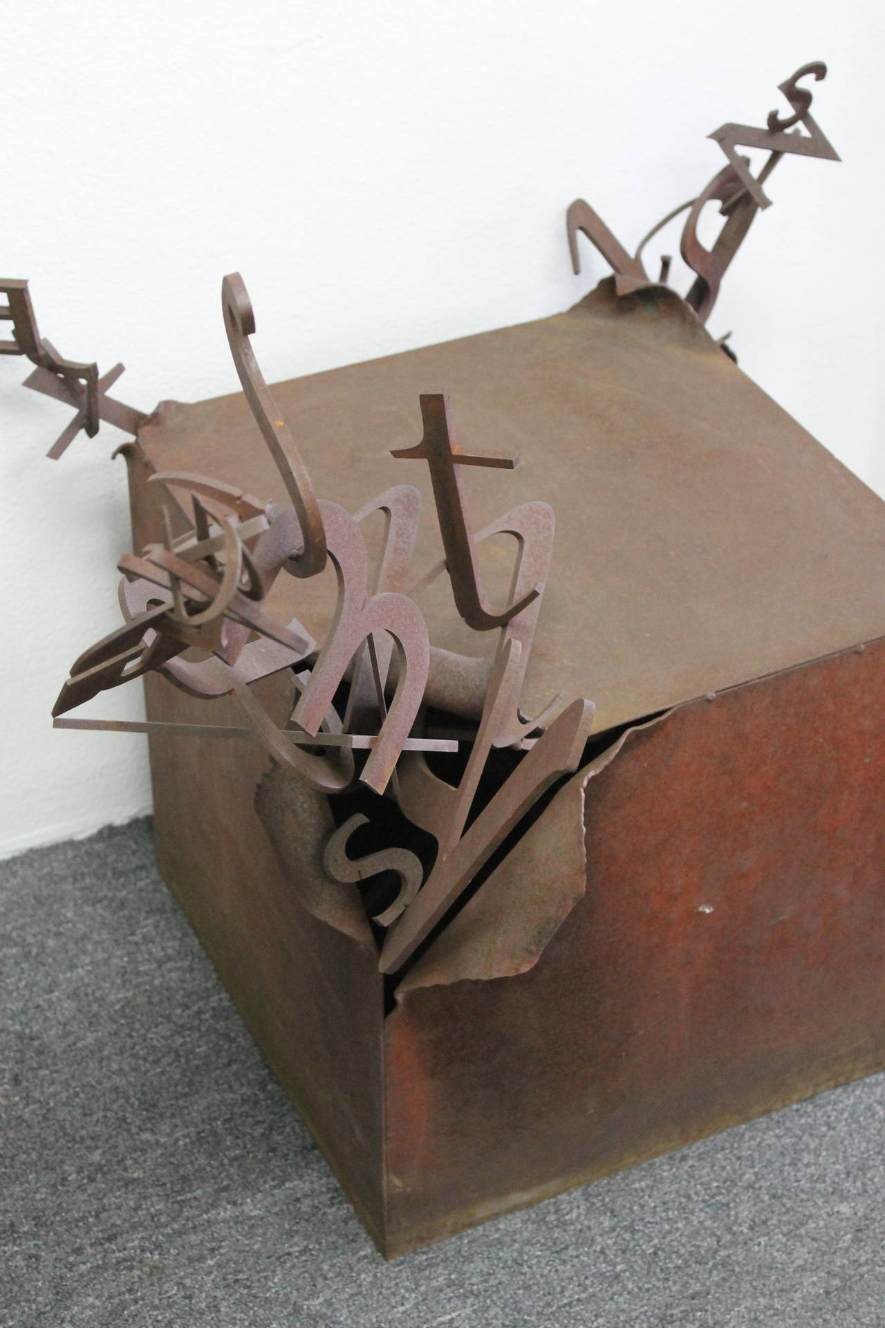 Steel box pedestal / sculpture with letters protruding out of 3 corners.  We call this the letter box and it was most likely used as a store prop.  Can be used as an indoor or outdoor sculpture.  The box without the letters is 17.5” wide, 17.5”deep