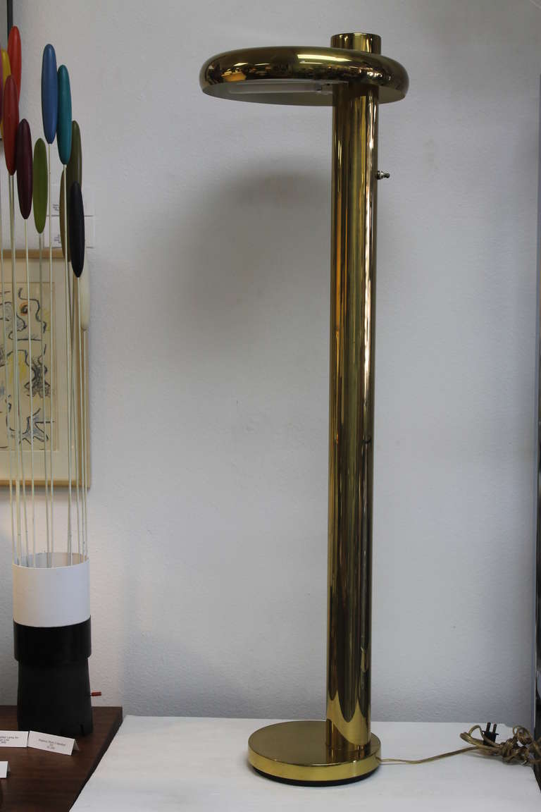 Modernist brass floor lamp by Koch and Lowy featuring cylindrical stem and rounded disc shade. This lamp is fitted for florescent bulbs. Height is 44”, shade is 12 3/4” and base is 8 1/4” wide.