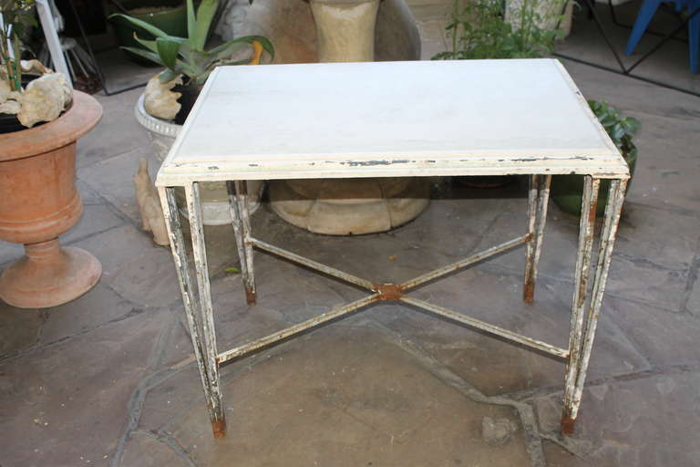 Antique iron and marble garden table. Early 20th century (possibly earlier) iron frame table with original beveled marble top. Top has one small fracture in the rear corner. The table measures 35” wide, 24 1/2” deep and 27 3/4” high. The marble