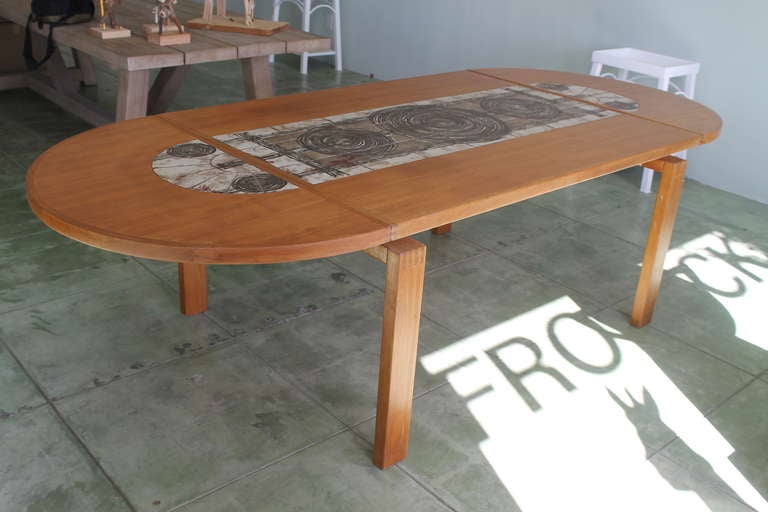 Drop-leaf dining or conference table, solid teak with hand made ceramic tile inserts. The tiles are signed 'Ox Art' with date of 1978. Table is marked Made in Denmark. Measures 57â?? long with leaves dropped. Leaves add another 22 1/2â?? each to the