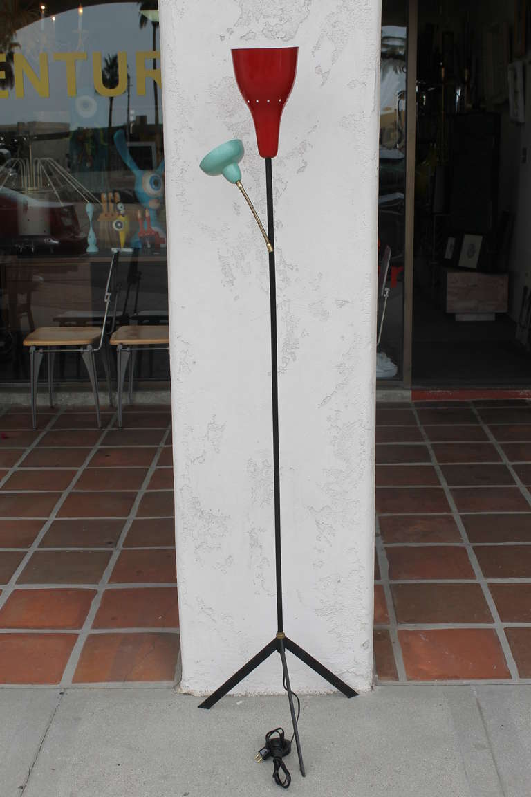 Gino Sarfatti attributed floor lamp with tripod base and dual lights. The small turquoise shade is mounted on a flexible gooseneck and houses a candelabra sized socket. The red shade is stationary and has a standard sized socket. Overall height is