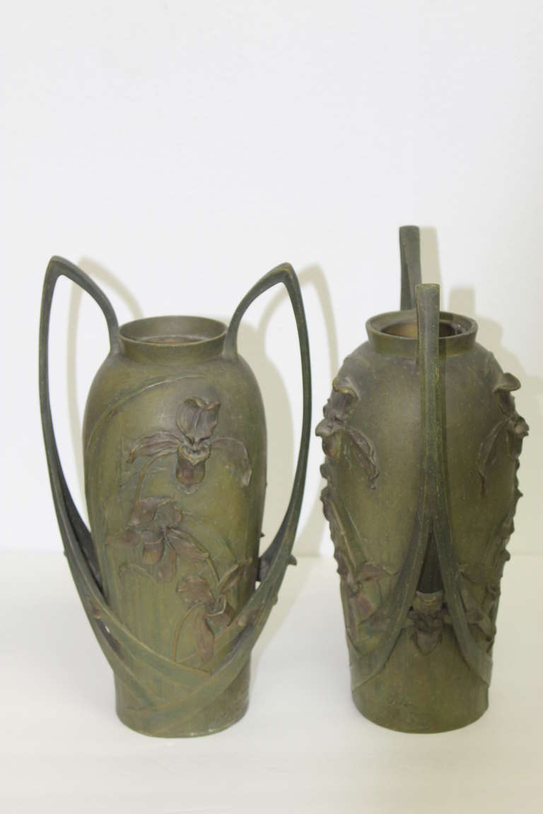 Pair of circa 1902, Art Nouveau vases with a two color patina bronzed surface. Cast in spelter metal, these vases are by the French sculptor, Blanche Poccard de Saintilau. They are signed along the edge “Salon 1902 Bl. Poccard.”
Each vase measures