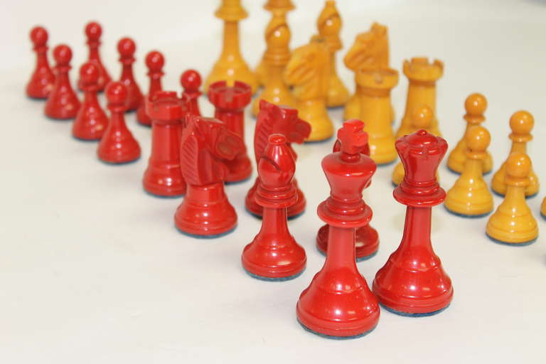 1930s bakelite cherry red and butterscotch yellow chess set.  Great chess set in desireable colors.  The bottoms are heavily padded/felted for the board and piece protection. No damage some slight color anomalies seem to be natural to the pieces. 