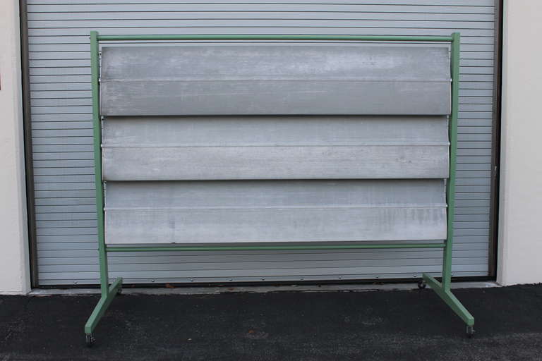 Three panel aluminum screen made of louvres from a cookie factory in Denver, Colorado.  They were used as sun blockers.  I purchased a couple of panels which were 15 feet high and had them cut in half.  Three 7.5 foot panels make up this screen