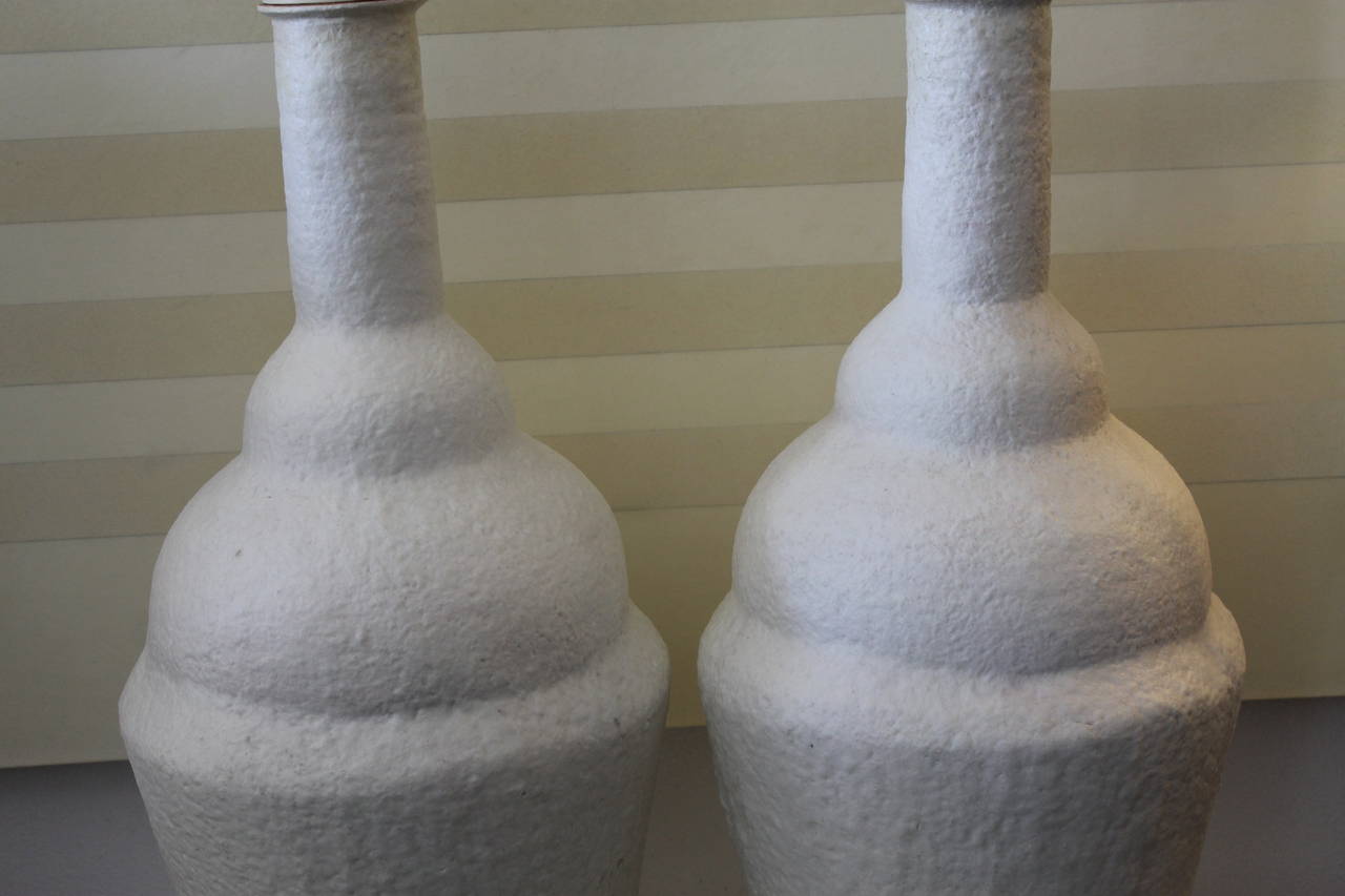 Pair of monumental sugar glaze lamps fully rewired on new Lucite bases. These lamps are both signed on the bottom but, we cannot decipher the maker or designer. Most likely Italian. Total height from base to the top of finial is 51". Ceramic
