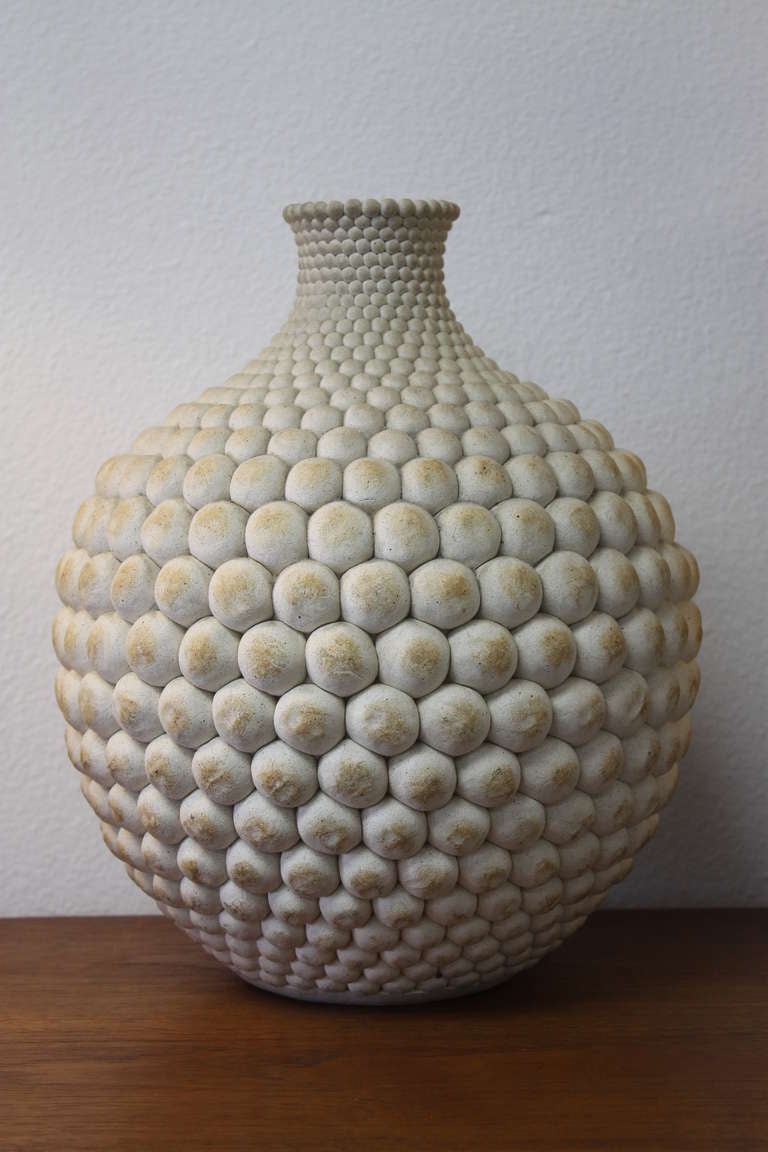 Large hand built buff colored stoneware vase constructed of hundreds of clay spheres, all assembled in graduating sizes to create a mesmerizing pattern. This superbly crafted  vase measures 14” tall and 11” wide. Signed Godart 81.