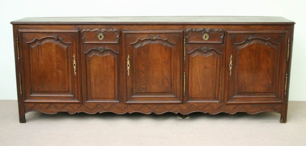An impressive oak French buffet, from the Picardie region, to the north of Paris. The unusual shaped cartouche drawers and the carved undulating apron are particular to this region of France.