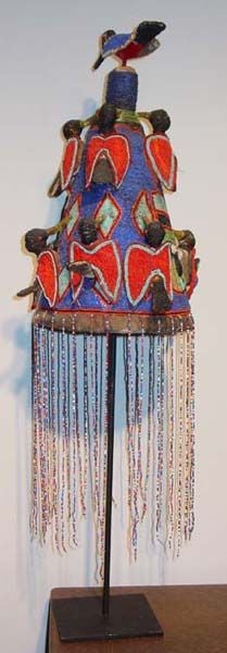 Beaded ceremonial ornaments were reserved for kings, certain priests and priestesses or specialists in medicinal herbs and divination.  The hand beaded conical crown with frontal faces, bird figures, and veil are said to represent the inner