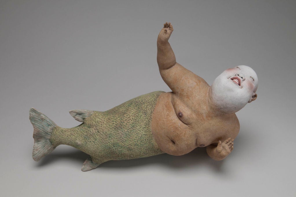 Esther Shimazu sculpts larger, bald figures in proud postures. Shimazu renders them sweet and spirited. They are often reclining and smirking.<br />
<br />
Sculpted mainly in stoneware and fired, the teeth, fingernails and toenails are porcelain