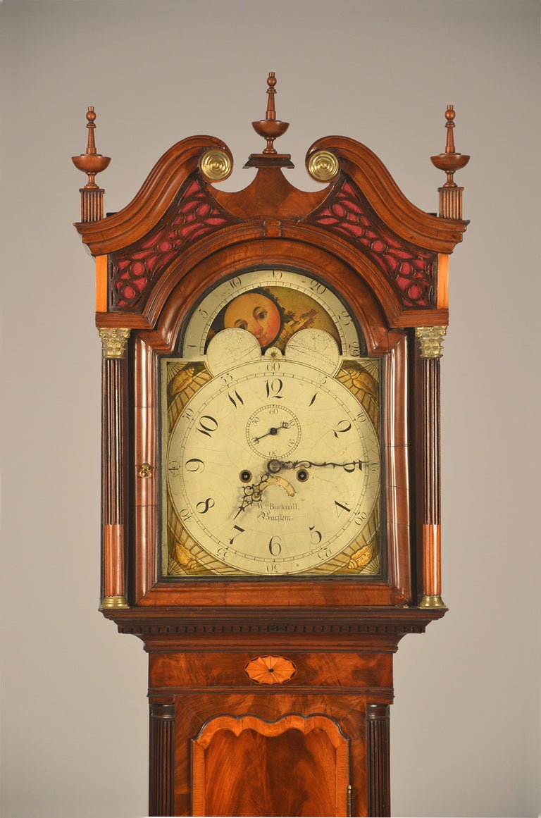 A superb, unusually small English inlaid mahogany long case clock signed William Bucknall, Burslem (halfway between Manchester and Liverpool).   The hood is topped with a  swan's neck crest above an open fretwork tympanium (that now has red fabric