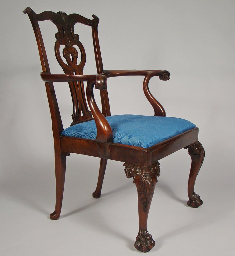 Superb Chippendale mahogany arm chair with hairy paw feet.
The serpentine top rail has shell carved ears with a carved fronds centered by a bold shell. The  splat is beautifully carved with volutes and fronds and a pendent husk.  
The arms have