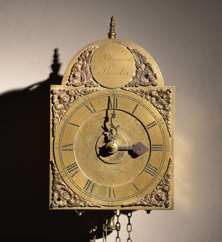 A rare English brass and iron traveling alarm lantern clock by Edward Blowers, Beccles (near Norwich)(lived: 1701 -1762)
This is an early 18th century type of lantern clock with an arched (tombstone) dial, the roundel in the arch is engraved
