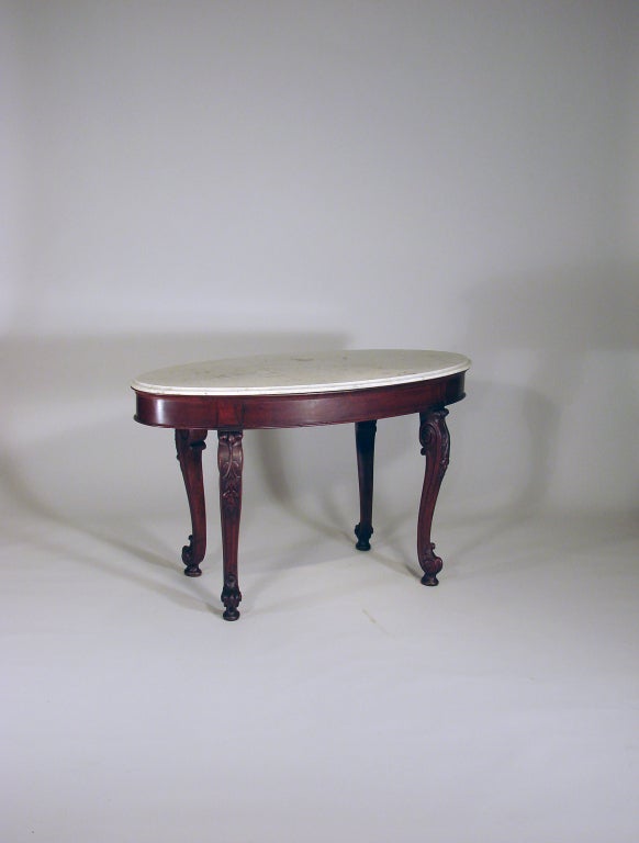 Wonderful small mahogany Anglo Indian oval center table retaining the original marble top with molded edge. Great carved cabriole legs.