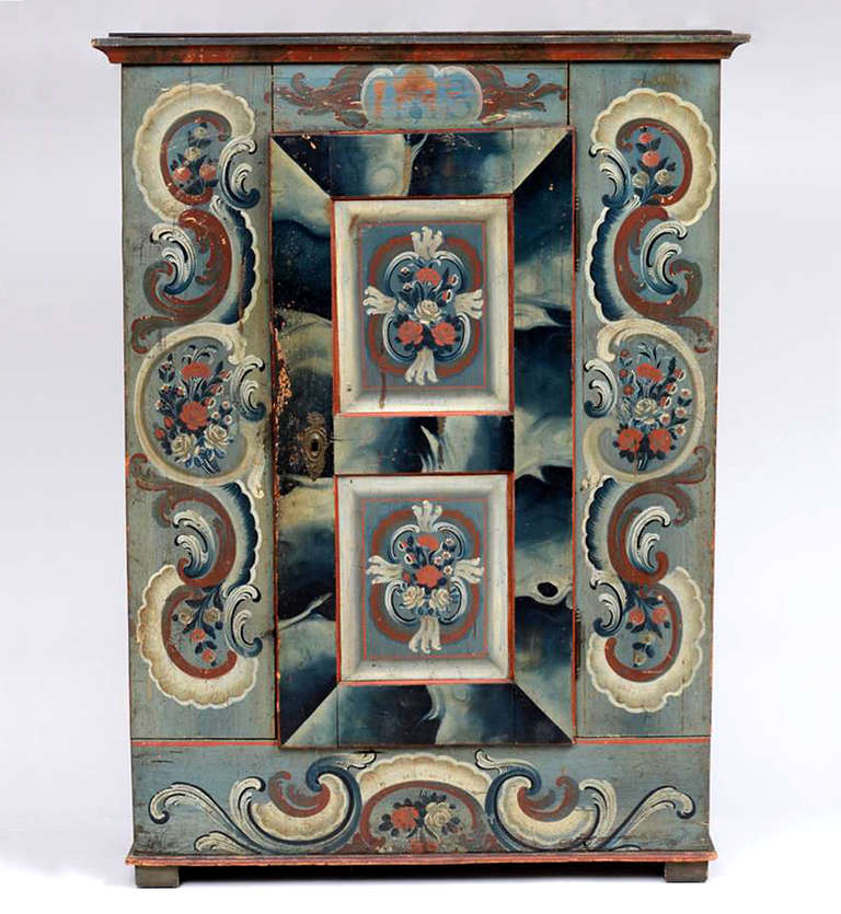 Wonderful Swiss provincial painted Armoire.
The cornice is marbleized and the case has floral sprays and rococo scrolls.
The door has a shaded periphery with two floral panels. 
Original shelves & lock and key, replaced back and the paint is