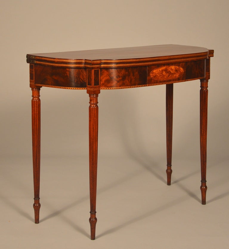 Superb Salem Mass. mahogany card table with turned and reeded legs.
The tops are matching single boards of Honduras highly figured mahogany.
The skirt features a raised rectangular mahogany quarter mitered panel with an oval of “flaming” birch