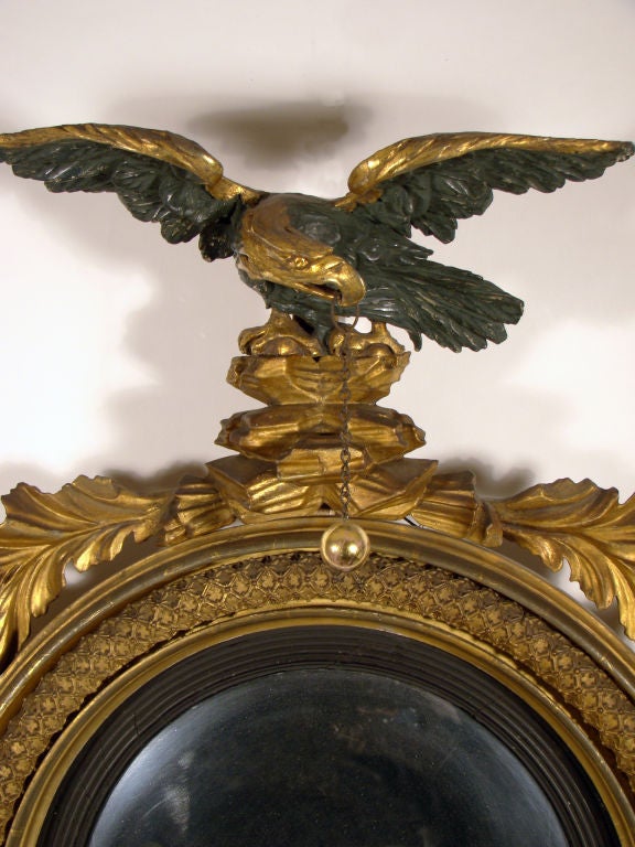 Very small English Regency giltwood girandole Mirror in superb original surface. The crest is an eagle with spread wings (retaining original Verde Antique) perched atop a rock base with oak branches and leaves on either side.

The convex mirror is