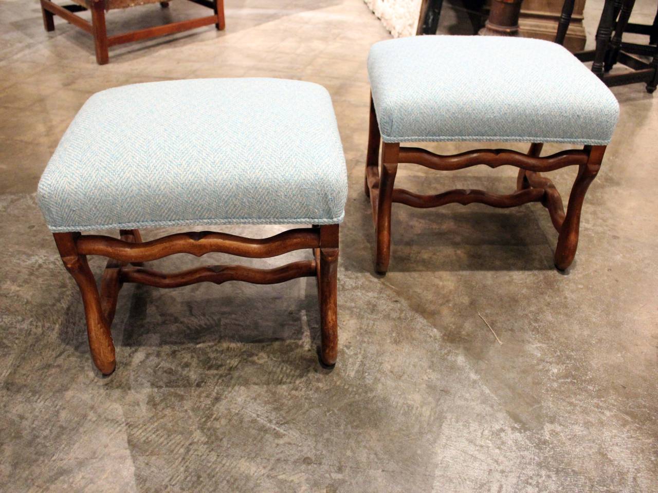 Pair of French walnut stools with shaped base and upholstered seat.