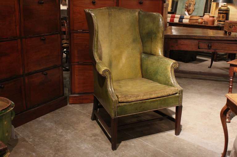English green leather wing chair.