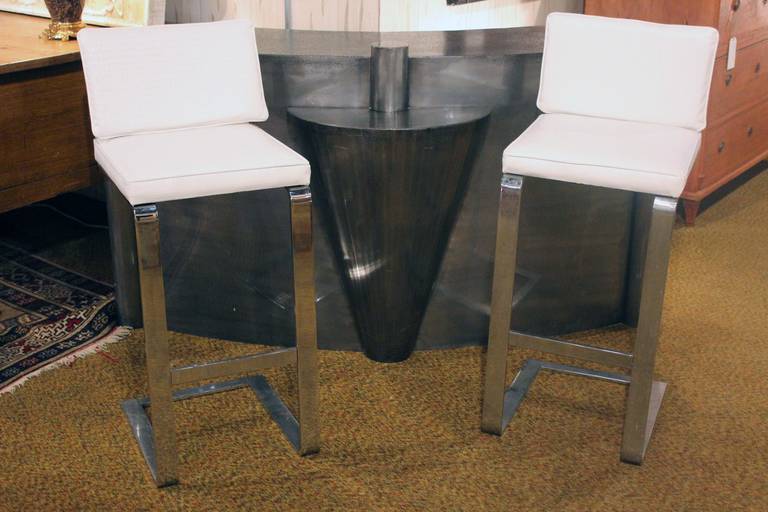 French metal cocktail bar set with curved front and ornamental accent in the center, pair of chrome and embossed faux leather barstools.
