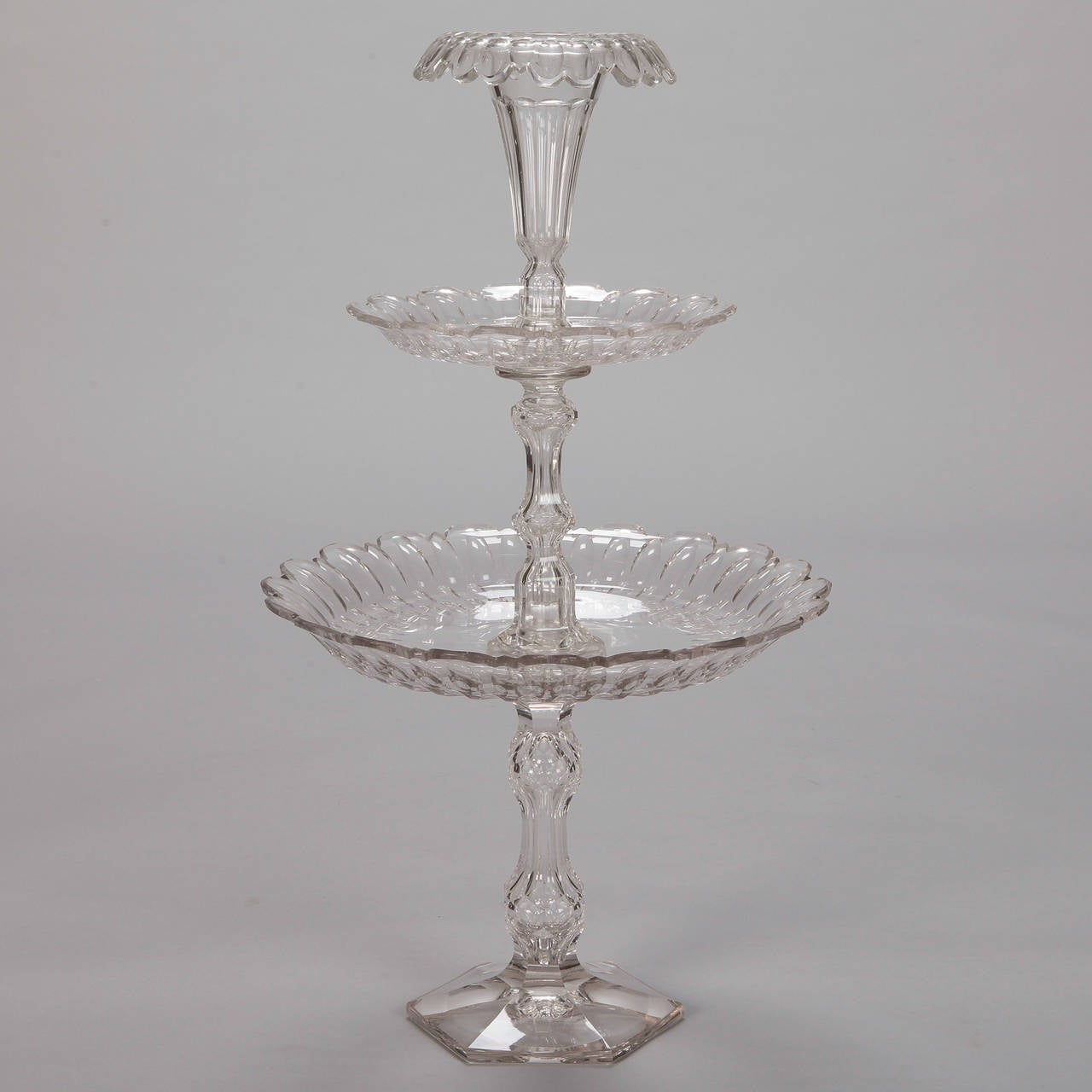 19th century English tall, cut crystal centerpiece. Pedestal base supports two plate tiers with scalloped edges and tulip shaped vase or vessel on top. Centerpiece tiers can be dismantled for shipping or storage.