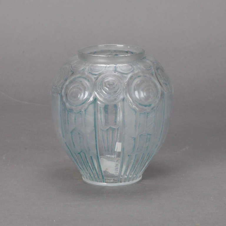 Small early French Art Deco vase in pale blue glass in a round form with molded glass Catteau-style abstract blooms around the top