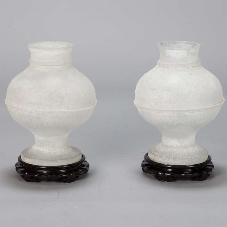 Circa 1960s pair of white scavo-style Murano glass vases by Seguso Vetri d’Arte feature pedestal bases, banded globe-form bodies with short, banded necks. Sold and priced as a pair.