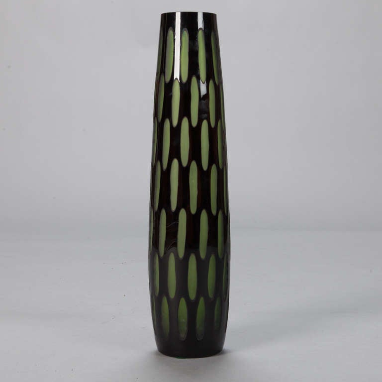 This circa 1960s tall and slender art case glass vase has a textured surface of polished olive green elongated ovals with contrasting black glass.