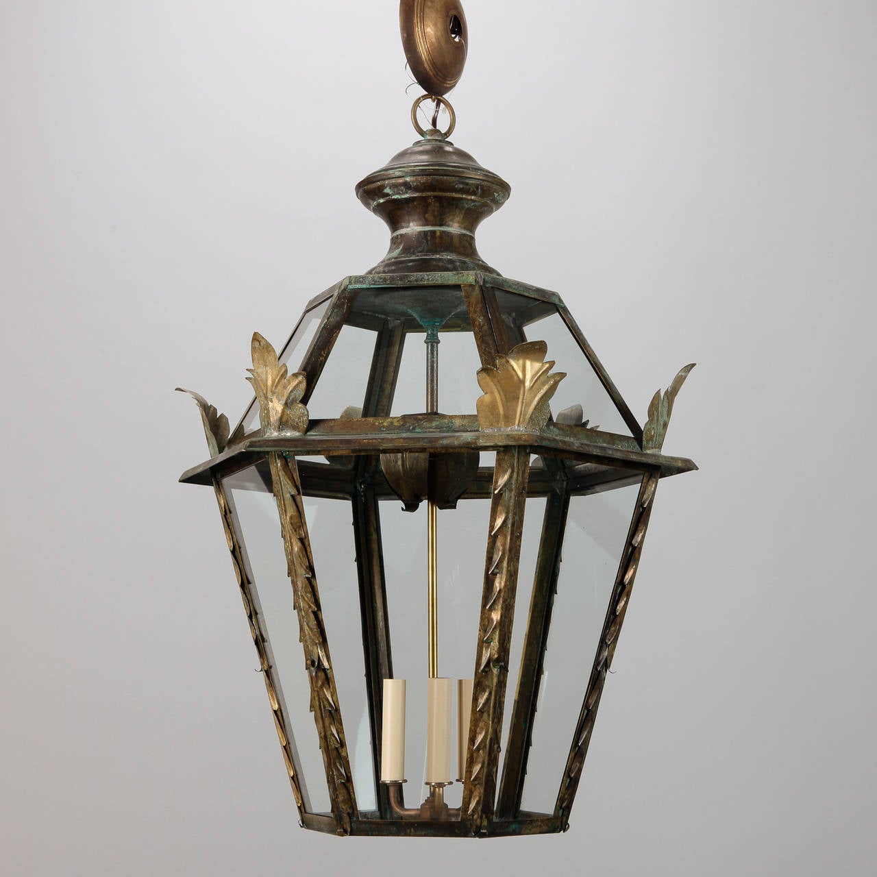 Circa 1980's large Italian dark brass lanterns with candle style lights, foliate form side supports and clear glass panels. New wiring for US electrical standards.
