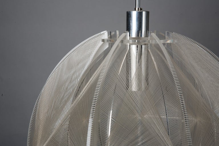 Circa 1970s hanging light fixture has a chromed central support with clear lucite wings that support an intricate white string form. New wiring for US electrical standards. We have another similar fixture with a more angular / geometric shape.