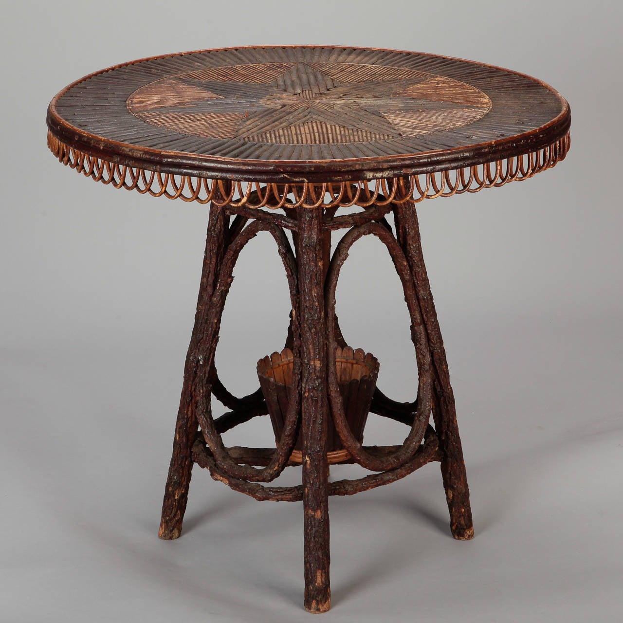 Circa 1920s French round table made with bent willow and twigs featuring a table top star inlay in contrasting light and dark woods.