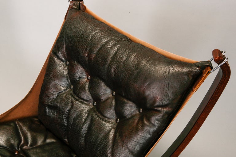 This pair of Falcon chairs was designed by Sigurd Resell and manufactured in the mid-1970s by Vatne Mobler in Norway. Chairs have rosewood frames and canvas slings that support dark brown leather button-tufted seats and backs. Seats are 18.5” high.