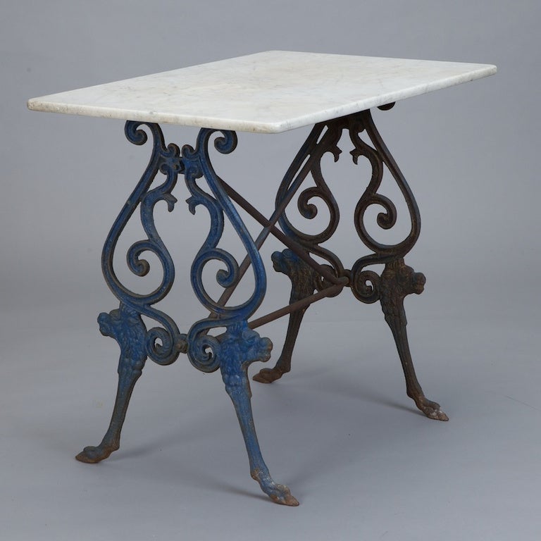 Circa 1930 French bistro table has decorative scrolled blue iron base and rectangular white marble top. Versatile size.