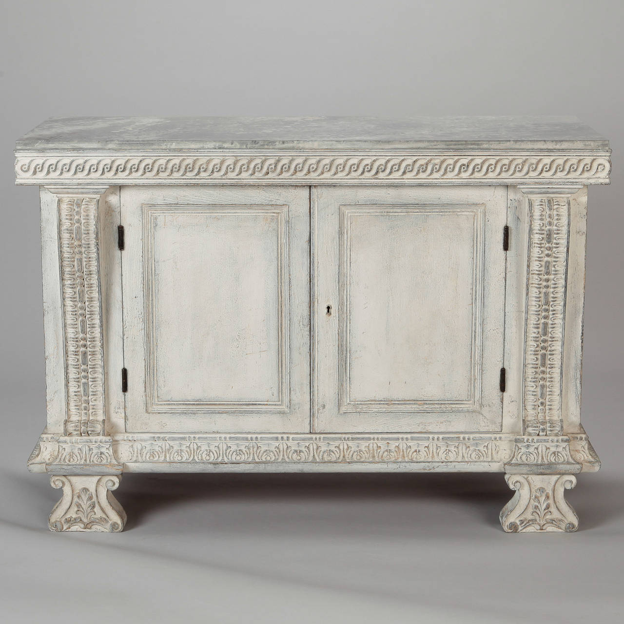 Circa 1920s Italian two door wood chest with white painted finish, faux painted top and carved details around the aprons, front supports and feet.