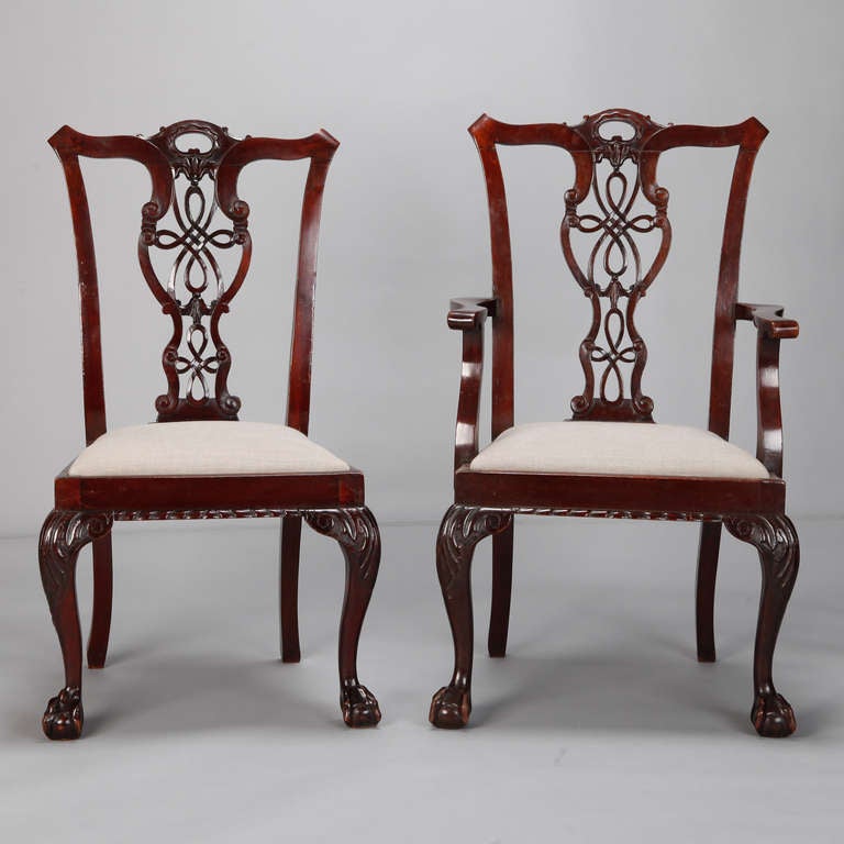 Circa 1880s English set of eight mahogany Chippendale style dining chairs. Two armchairs and six side chairs. Frames have gorgeous, carved open work back splats, ball and claw cabriole front legs and seats are newly upholstered in natural colored