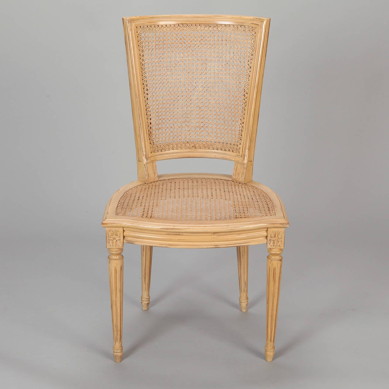 Circa 1930s set of six French chairs with antique earthy mustard painted finish, caned backs and seats. Color matches Pantone 7507 / 7508C.  Seats are 17.5” high and 16.5” deep. Sold and priced as a set.