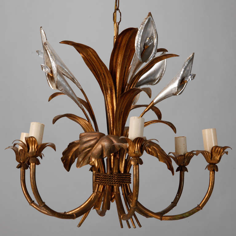 Circa 1940s Italian six light tole chandelier has a gilded flower and leaf form frame with silver gilt calla lily blooms accented by clear crystal centers. Six candle style lights have been rewired for US electrical standards.
# of Sockets: 