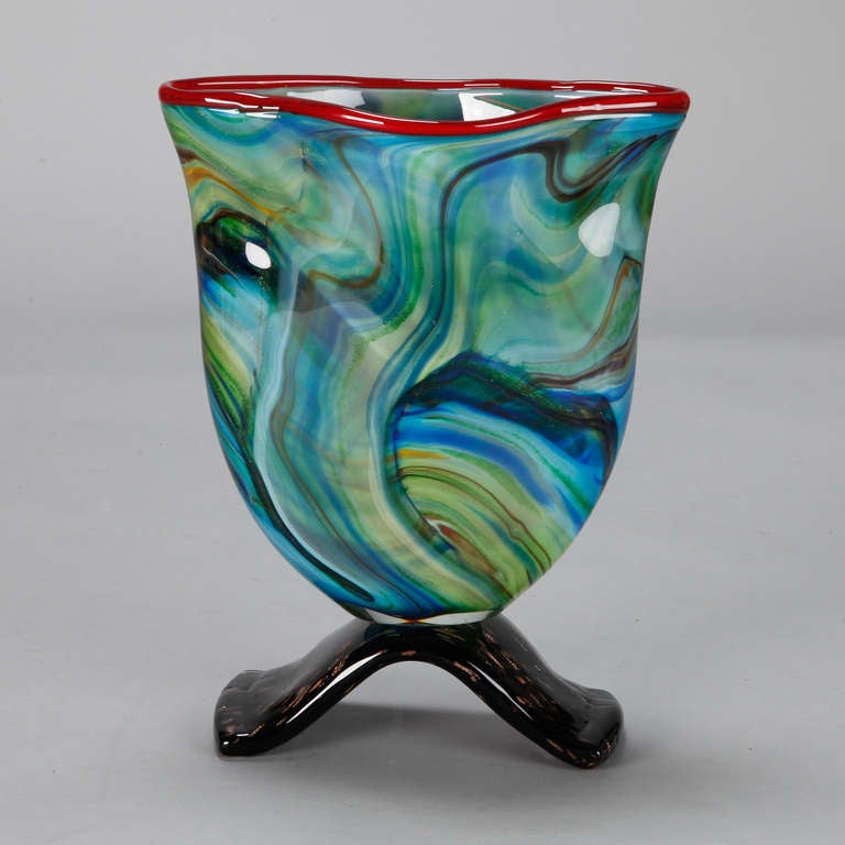 Art Deco era Murano art glass vase of swirled, vibrant shades of blue and green with red rim and black footed base.