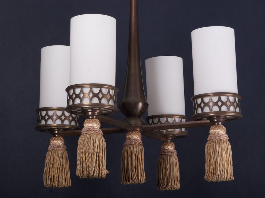 This distinctive antique French ceiling fixture is  made of metal with a bronze finish. Each of the four lights is set in a decorative open-work base finished with an oversized tassel and frosted glass.
# of Sockets:  4
Socket Type:  Candelabra