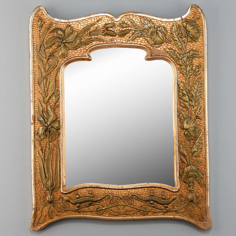 Circa 1910 French Art Nouveau gilt metal framed mirror with beautifully rendered designs of irises and lizards in relief.