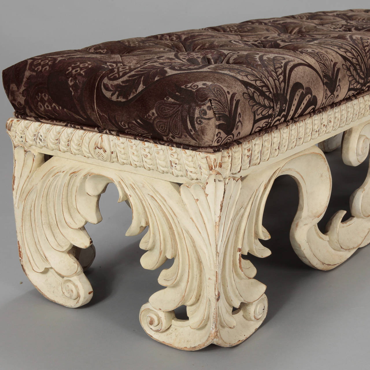 CIrca 1960s Italian upholstered bench with heavily carved open work base and white painted finish. Upholstered in printed velvet fabric