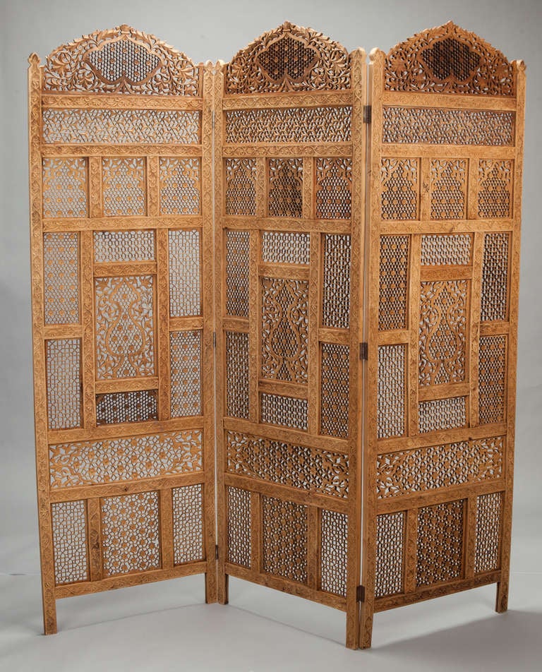 Circa 1870s elaborately carved Indian open work folding screen has three hinged panels. Each section is 23” wide. 
