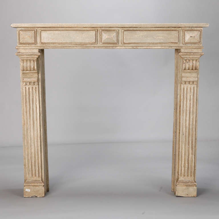 Circa 1930s French carved wood fireplace mantel has gray painted finish and two reeded column form supports.