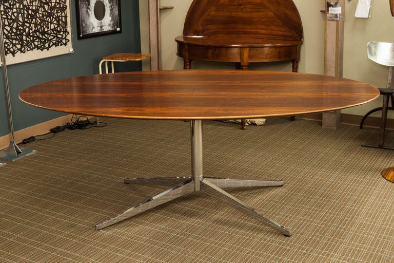 Circa 1960s oval conference / dining table designed by Florence Knoll of Brazilian rosewood with chrome pedestal base. Excellent condition and beautiful grain with original finish which shows some areas of wear.  